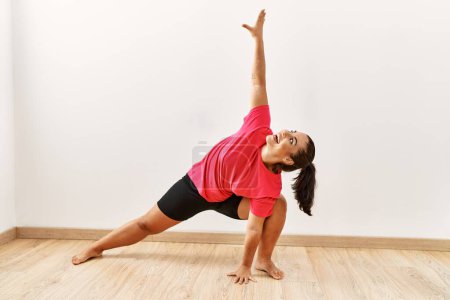 Photo for Young beautiful hispanic woman smiling confident training yoga at sport center - Royalty Free Image