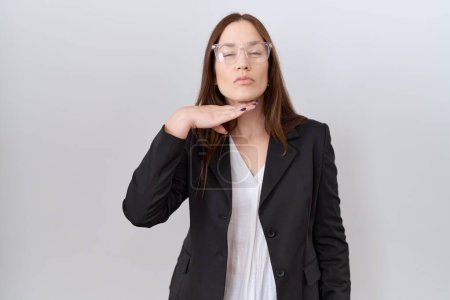 Foto de Hermosa mujer morena vistiendo chaqueta de negocios y gafas degollando con la mano como cuchillo, amenazan la agresión con violencia furiosa - Imagen libre de derechos