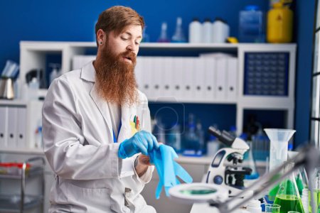 Photo for Young redhead man scientist wearing gloves at laboratory - Royalty Free Image