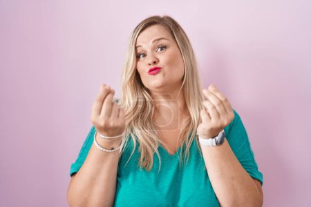 Photo for Caucasian plus size woman standing over pink background doing money gesture with hands, asking for salary payment, millionaire business - Royalty Free Image
