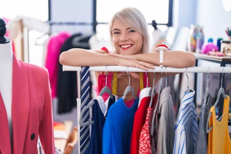 Photo for Young blonde woman tailor smiling confident leaning on clothes rack at gaming room - Royalty Free Image