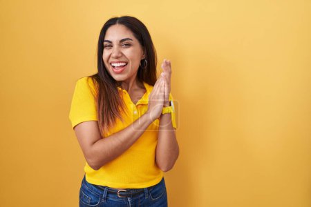 Téléchargez les photos : Jeune femme arabe debout sur fond jaune applaudissements et applaudissements heureux et joyeux, souriant mains fiers ensemble - en image libre de droit