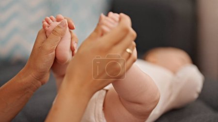 Photo for Mother and daughter holding feet at home - Royalty Free Image