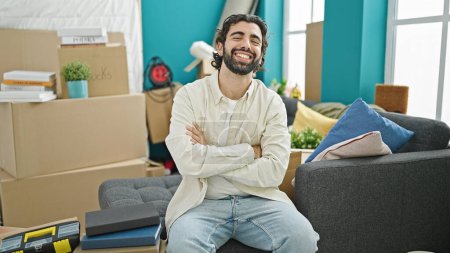 Photo for Young hispanic man smiling confident sitting on sofa with arms crossed gesture at new home - Royalty Free Image