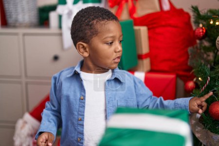 Téléchargez les photos : Africain américain garçon décoration arbre de Noël à la maison - en image libre de droit