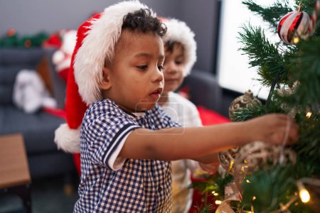 Photo for Adorable boys decorating christmas tree at home - Royalty Free Image