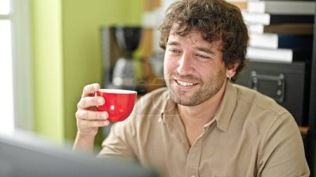 Photo for Young hispanic man business worker using computer drinking coffee at office - Royalty Free Image