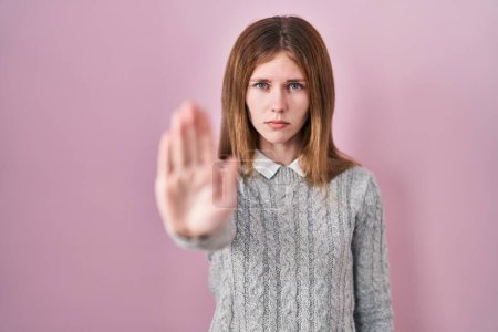 Photo for Beautiful woman standing over pink background doing stop sing with palm of the hand. warning expression with negative and serious gesture on the face. - Royalty Free Image