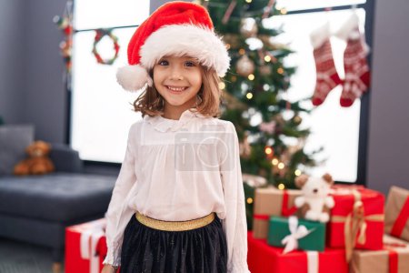 Photo for Adorable hispanic girl smiling confident standing by christmas tree at home - Royalty Free Image
