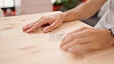 Téléchargez les photos : Jeune homme hispanique touchant table avec les doigts à la salle à manger - en image libre de droit