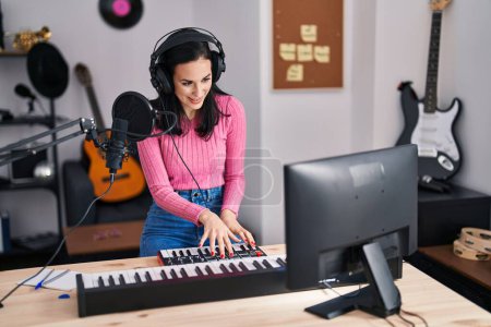Téléchargez les photos : Jeune musicienne caucasienne jouant du piano au studio de musique - en image libre de droit