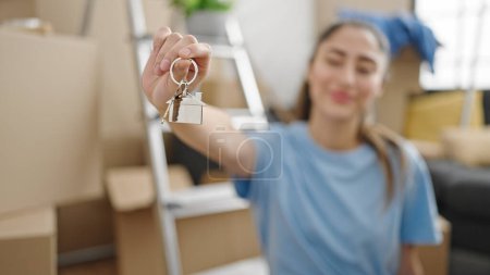 Photo for Young beautiful hispanic woman smiling confident holding new house keys at new home - Royalty Free Image