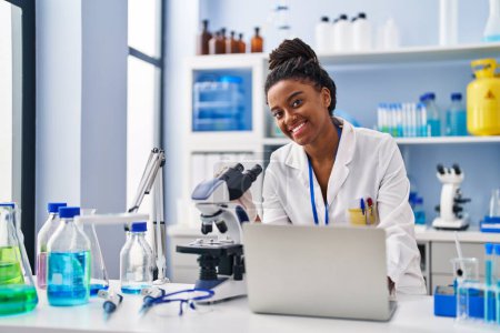 Foto de African american woman scientist using laptop working at laboratory - Imagen libre de derechos