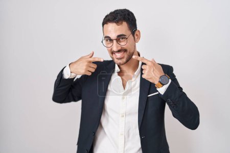 Téléchargez les photos : Beau homme d'affaires hispanique debout sur fond blanc souriant et joyeux montrant et pointant avec les doigts les dents et la bouche. concept de santé dentaire. - en image libre de droit