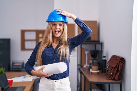 Photo for Young woman wearing architect hardhat stressed and frustrated with hand on head, surprised and angry face - Royalty Free Image