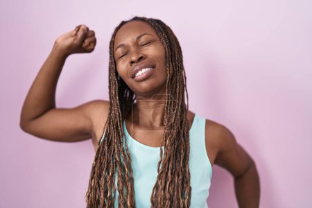 Foto de Mujer afroamericana de pie sobre fondo rosa que se extiende hacia atrás, cansada y relajada, soñolienta y bostezando por la mañana temprano - Imagen libre de derechos