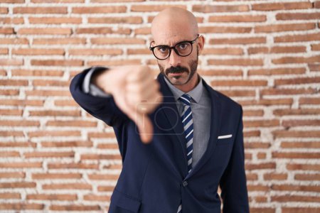 Photo for Bald man with beard wearing business clothes and glasses looking unhappy and angry showing rejection and negative with thumbs down gesture. bad expression. - Royalty Free Image