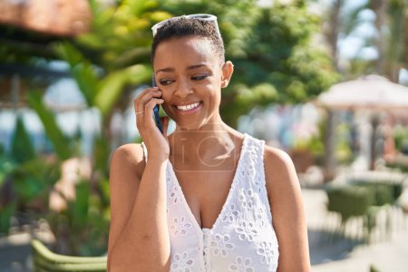 Photo for African american woman smiling confident talking on the smartphone at park - Royalty Free Image
