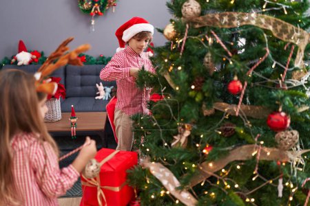 Foto de Hermano y hermana decorando el árbol de Navidad en casa - Imagen libre de derechos