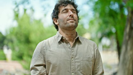 Téléchargez les photos : Young hispanic man breathing with closed eyes at park - en image libre de droit