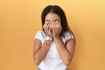 Photo for Young arab woman wearing casual white t shirt over yellow background rubbing eyes for fatigue and headache, sleepy and tired expression. vision problem - Royalty Free Image