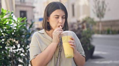 Téléchargez les photos : Jeune belle femme hispanique buvant du thé bulle dans les rues de Vienne - en image libre de droit