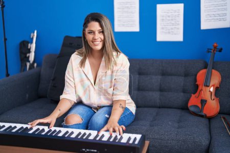 Téléchargez les photos : Jeune musicienne hispanique jouant du clavier piano au studio de musique - en image libre de droit