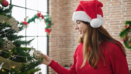 Téléchargez les photos : Jeune femme hispanique décorer arbre de Noël à la maison - en image libre de droit