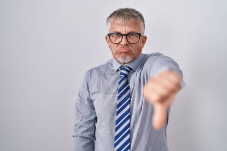 Photo for Hispanic business man with grey hair wearing glasses looking unhappy and angry showing rejection and negative with thumbs down gesture. bad expression. - Royalty Free Image