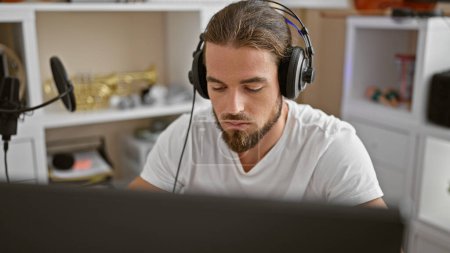Téléchargez les photos : Jeune musicien hispanique écoutant de la musique au studio de musique - en image libre de droit