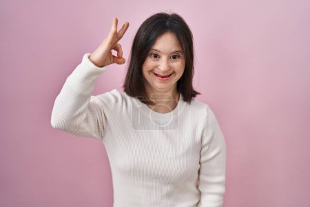 Téléchargez les photos : Femme avec le syndrome du duvet debout sur fond rose souriant positif faire ok signe avec la main et les doigts. expression réussie. - en image libre de droit
