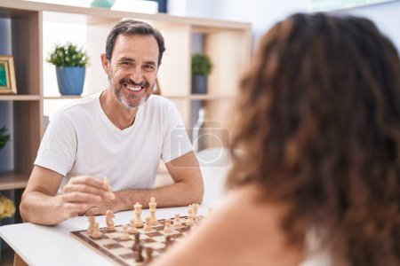 Téléchargez les photos : Man and woman smiling confident playing chess game at home - en image libre de droit