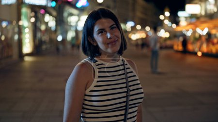 Photo for Young beautiful hispanic woman smiling confident standing in the streets at night - Royalty Free Image