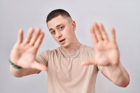 Téléchargez les photos : Jeune homme debout sur fond isolé faisant cadre en utilisant les mains paumes et les doigts, perspective de la caméra - en image libre de droit