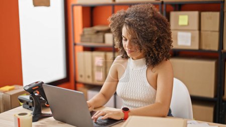 Téléchargez les photos : Jeune belle hispanique femme commerce électronique travailleur d'affaires en utilisant un ordinateur portable travaillant au bureau - en image libre de droit