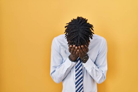Photo for African man with dreadlocks standing over yellow background with sad expression covering face with hands while crying. depression concept. - Royalty Free Image