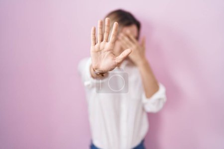 Photo for Young beautiful woman standing over pink background covering eyes with hands and doing stop gesture with sad and fear expression. embarrassed and negative concept. - Royalty Free Image