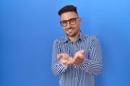 Photo for Hispanic man with beard wearing glasses smiling with hands palms together receiving or giving gesture. hold and protection - Royalty Free Image