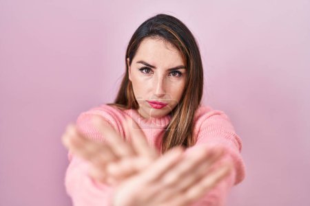 Téléchargez les photos : Jeune femme hispanique debout sur fond rose expression de rejet croisement des bras et des paumes faisant signe négatif, visage en colère - en image libre de droit