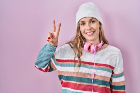 Photo for Young blonde woman standing over pink background showing and pointing up with fingers number two while smiling confident and happy. - Royalty Free Image