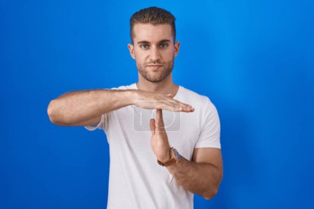 Téléchargez les photos : Jeune homme caucasien debout sur fond bleu faisant un geste avec les mains, frustré et sérieux visage - en image libre de droit