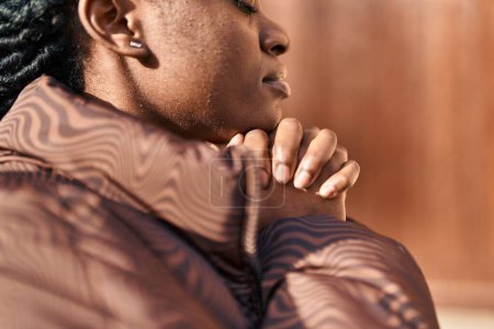 Téléchargez les photos : African american woman praying with closed eyes at street - en image libre de droit