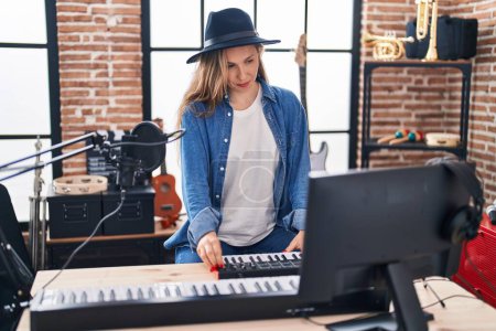 Téléchargez les photos : Jeune femme blonde musicienne ayant une session de DJ au studio de musique - en image libre de droit