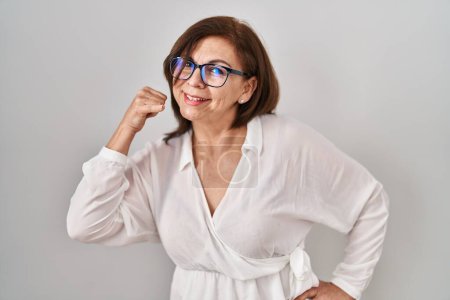 Photo for Middle age hispanic woman standing over isolated background smiling doing phone gesture with hand and fingers like talking on the telephone. communicating concepts. - Royalty Free Image