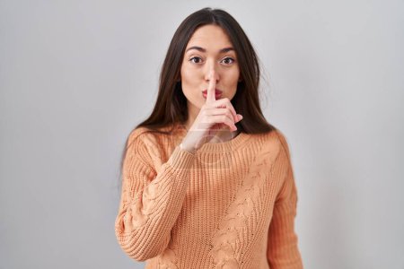 Photo for Young brunette woman standing over white background asking to be quiet with finger on lips. silence and secret concept. - Royalty Free Image