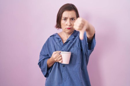 Photo for Middle age hispanic woman drinking a cup coffee looking unhappy and angry showing rejection and negative with thumbs down gesture. bad expression. - Royalty Free Image