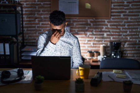 Téléchargez les photos : Jeune homme hispanique travaillant au bureau la nuit fatigué se frottant le nez et les yeux ressentant fatigue et maux de tête. concept de stress et de frustration. - en image libre de droit