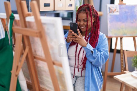 Téléchargez les photos : Femme artiste afro-américaine souriante confiante faire une photo pour dessiner au studio d'art - en image libre de droit