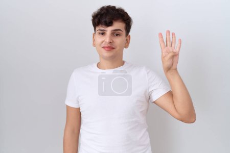 Téléchargez les photos : Jeune homme non binaire portant t-shirt blanc décontracté montrant et pointant vers le haut avec les doigts numéro quatre tout en souriant confiant et heureux. - en image libre de droit