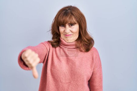 Photo for Middle age hispanic woman standing over isolated background looking unhappy and angry showing rejection and negative with thumbs down gesture. bad expression. - Royalty Free Image